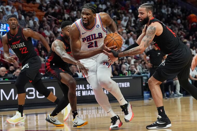 Sixers center Joel Embiid breaks away from Miami Heat forward Haywood Highsmith (left) and forward Caleb Martin on Thursday.