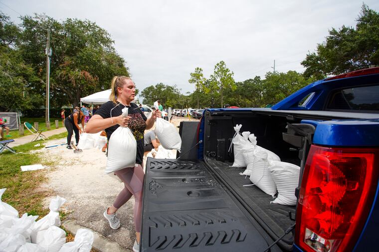 Victoria Colson, 31, of Tampa loads sandbags into her truck along with other Tampa residents who waited for more than two hours at Himes Avenue Complex to fill their 10 free sandbags on Sunday.