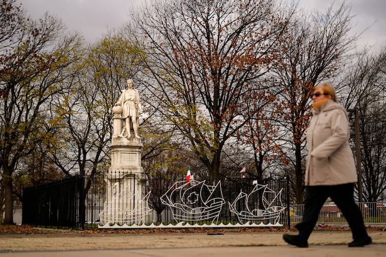 A person walks by the statue of Christopher Columbus at Marconi Plaza on Dec. 12. Philadelphia removed the plywood box it placed over the statue after 2020 protests over racial injustice.