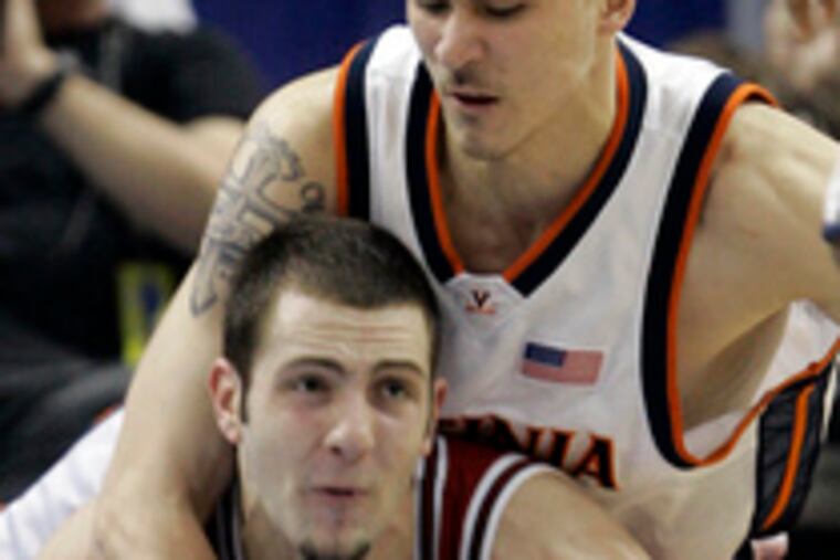 Wrestling for a loose ball during Friday's game are Virginia's Jason Cain (top) and N.C. State's Brandon McCauley.