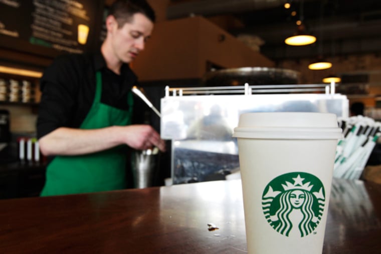 FILE - In this Friday, April 27, 2012, photo, a Starbucks drink waits for a customer to pick it up as barista Josh Barrow prepares another. (AP Photo/Ted S. Warren, File)