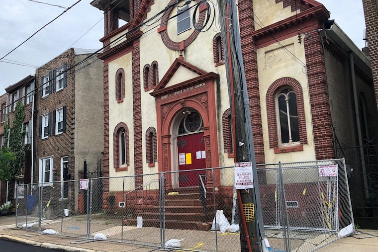 A fence now sits around the perimeter of the Christian Street Baptist Church, while a bright yellow demolition notice hangs on the door.