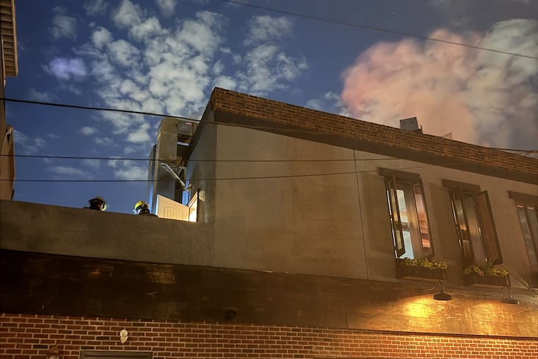 Firefighters work on the roof of Ember & Ash on June 24, 2026.