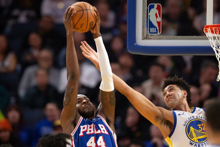 Sixers forward Paul Reed (44) and Warriors forward Trayce Jackson-Davis (32) battle for a rebound during the first half of their game on Tuesday. The Sixers fell, 119-107.
