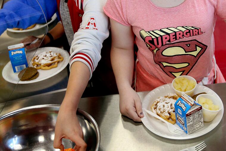 FILE - In this Friday, May 19, 2017 file photo, students line up for lunch at a middle school in Sandy, Utah. On Thursday, Dec. 6, 2018, the U.S. Department of Agriculture announced the scaling back contested school lunch standards implemented under the Obama administration, including one that required only whole grains be served.