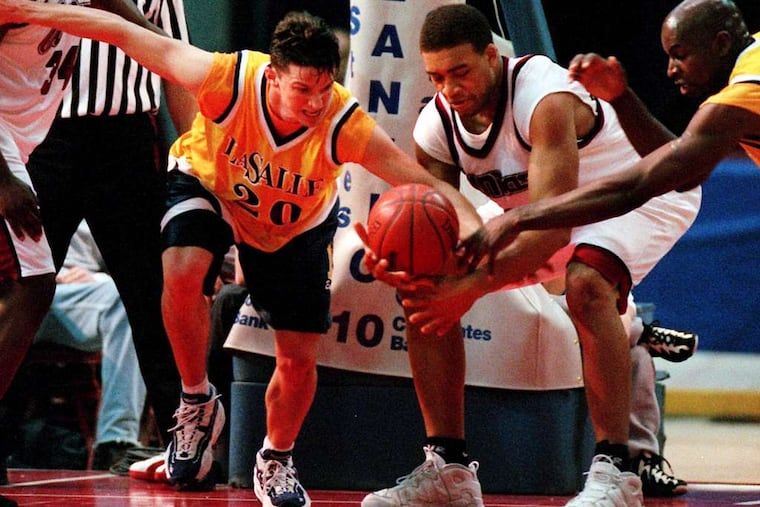 Lari Ketner (second from right), in his UMass playing days, battles for the ball with La Salle's Mike Gizzi in a 1997 game. Ketner died Friday. Inquirer File Photograph