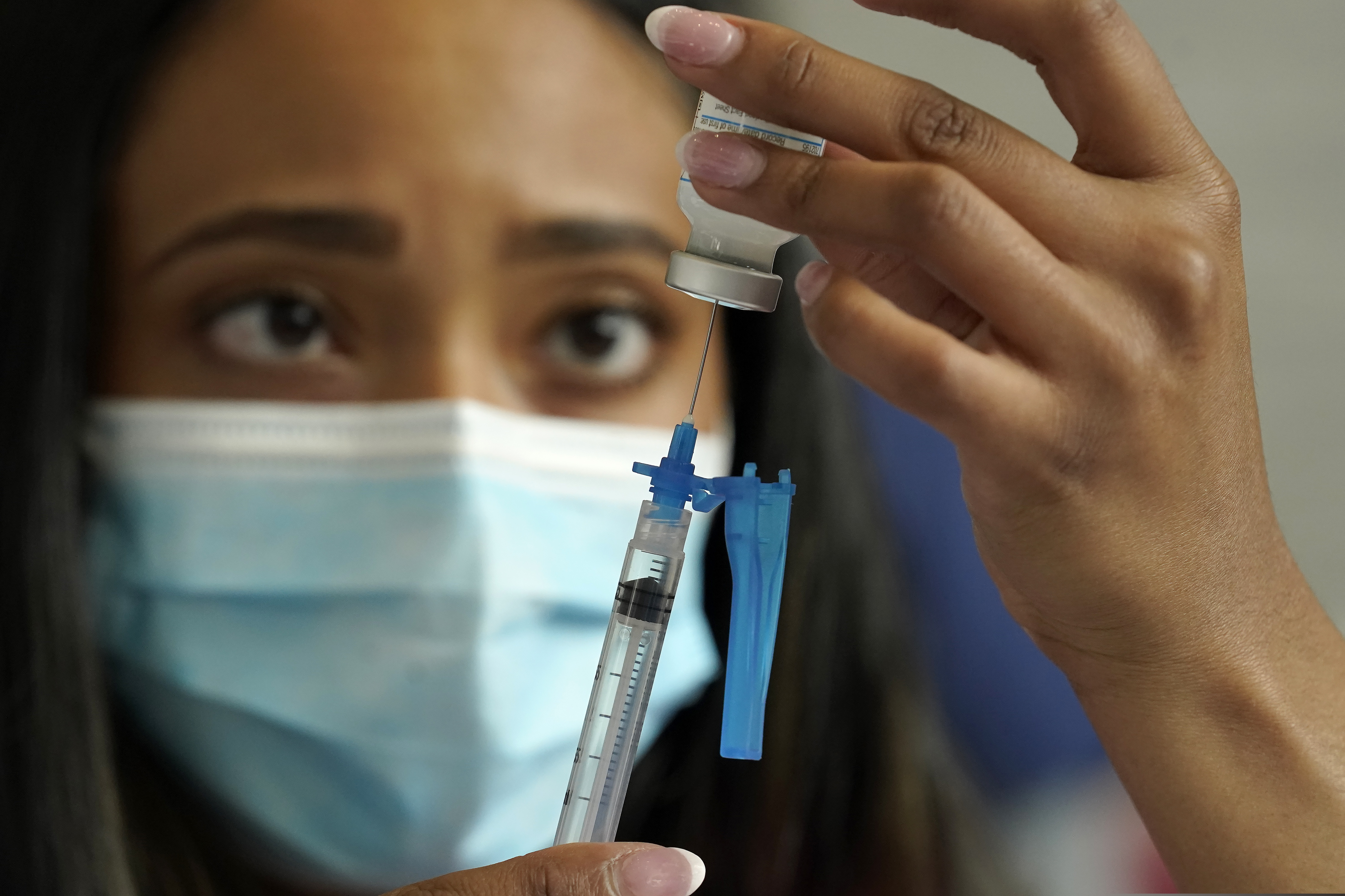 In this May 19 photo, a licensed practical nurse draws a Moderna COVID-19 vaccine into a syringe at a mass vaccination clinic at Gillette Stadium in Foxborough, Mass.