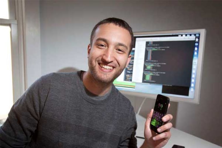 Loren Brichter's smartphone is running Letterpress, with the code on the computer screen. (Ed Hille / Staff Photographer)