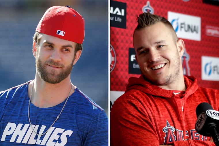 New Phillies outfielder Bryce Harper (left) said he would work hard to convince Los Angeles Angels superstar Mike Trout (right) to join the team when he becomes a free agent in 2020.