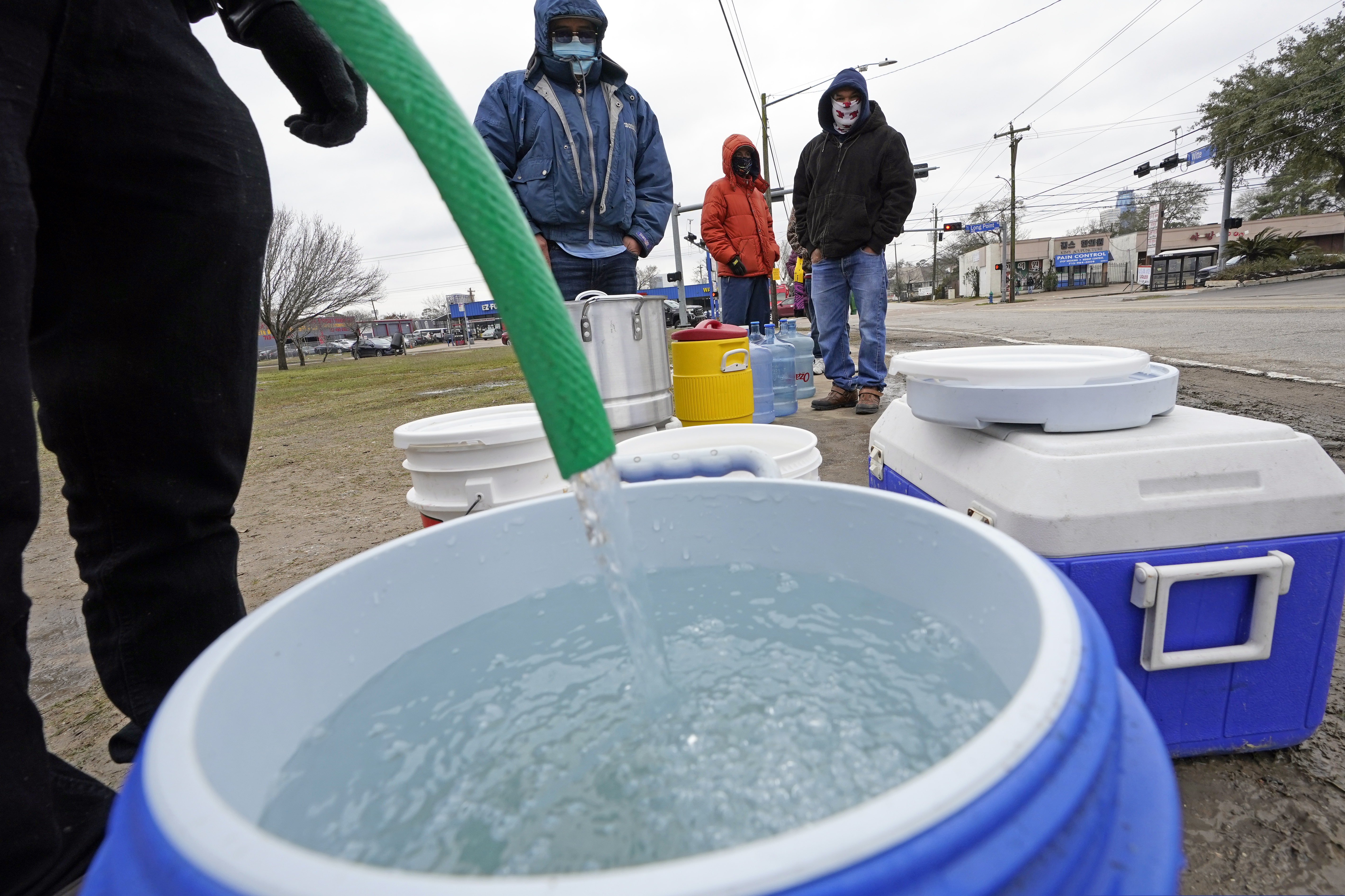 A water bucket was filled as others waited in near-freezing temperatures to use a hose from public park spigot Thursday in Houston.