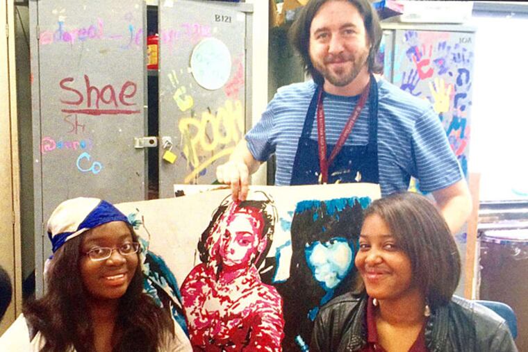 Art teacher Chris Palmer with students Shanta Moulton (left) and Saddyia Washington at Bartram High. Palmer reached students in a way few are able to do, Moulton said. The program is being cut from the school for budgetary reasons.