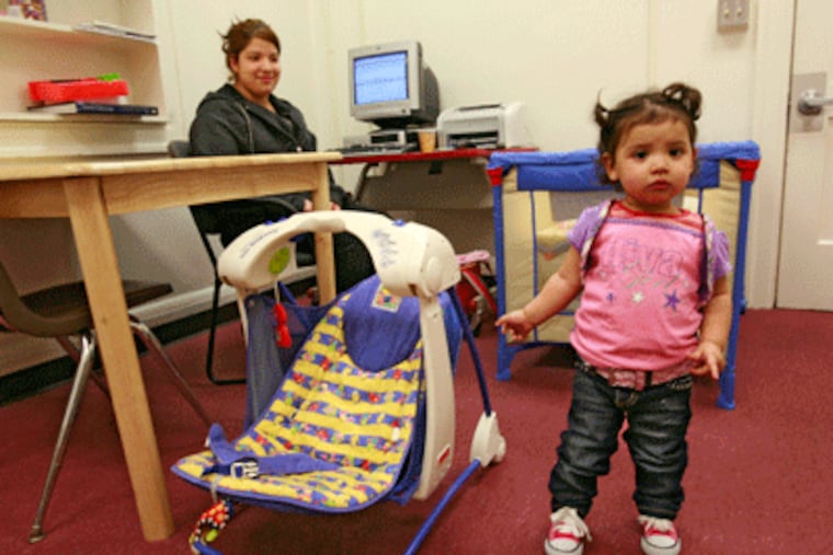 Jessica Gonzalez, 17, keeps an eye on her daughter Shaylin while working on a school assignment in a room set aside for mothers at the John Hope Education Center in Indianapolis. The center specializes in teaching students who are at particular risk of failing in school and dropping out -- expectant teens and young mothers. (AP Photo/The Indianapolis Star, Michelle Pemberton)