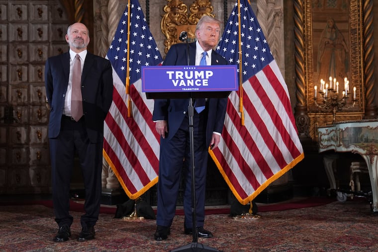 President-elect Donald Trump speaks at a news conference at Mar-a-Lago, on Monday in Palm Beach, Fla., as Commerce Secretary nominee Howard Lutnick listens.