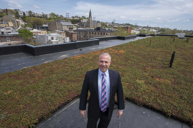 Ralph Kearney, property manager of The Isle apartment building in Manayunk, on the roof with portion of the rooftop garden — installed for absorbing rainwater to lessen the possibility of flooding.