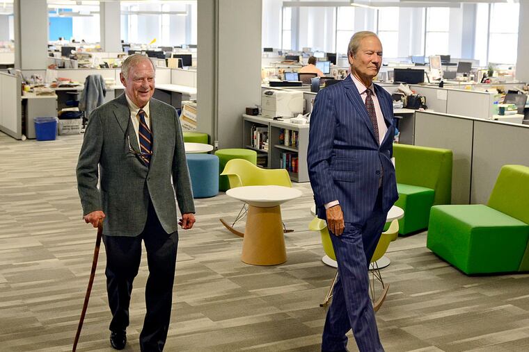Inquirer co-owners H.F. "Gerry" Lenfest (left) and Lewis Katz (right) walk through an empty newsroom May 27, 2014 en route to a meeting with the staff (all waiting for their arrival in nearby meeting room) hours after winning the auction for the parent company of the newspaper. ( TOM GRALISH / Staff Photographer )