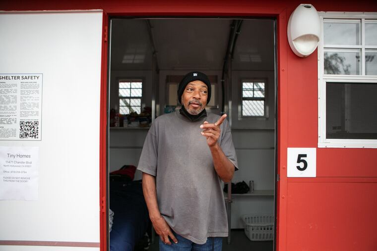 Stephen Smith stands in the doorway of the tiny home he occupies at Chandler Street Tiny Home Village in North Hollywood, Calif.