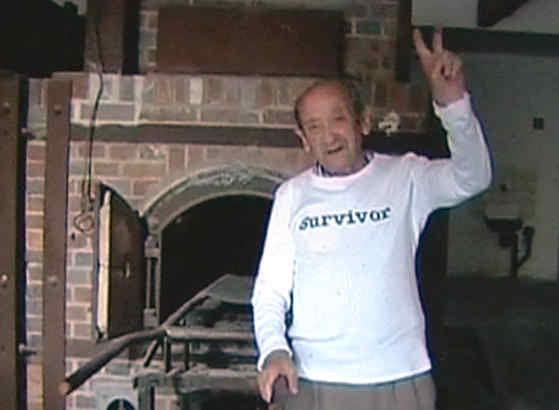 Auschwitz survivor Adolek Kohn flashes a victory sign before an oven. After thousands of hits, YouTube took the video down.