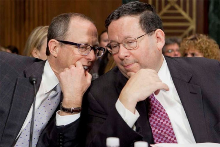 Comcast's David L. Cohen and Randal Milch, of Verizon Communications, speak before testifying at a 2012 hearing on a deal between the companies. (Andrew Harrer / Bloomberg)
