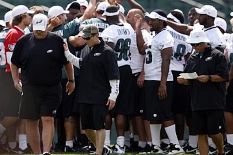 Howie Roseman consoles Andy Reid at Eagles training camp on Wednesday. (David Maialetti/Staff Photographer)