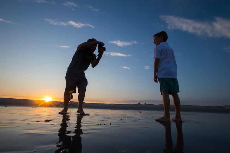 Photographer Andy Macpherson, left, photographs some individual shots of Samuel Lester, 7, at the 27th Street Beach in Avalon earlier this month. It should be near picture-perfect at the Shore this weekend.