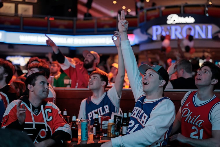 Sixers and Flyers fans including Jackson Debusschere of Wallingford (far left) and Luke Jacobson of Media (second from right) watch both games at Stateside Live! on Saturday.