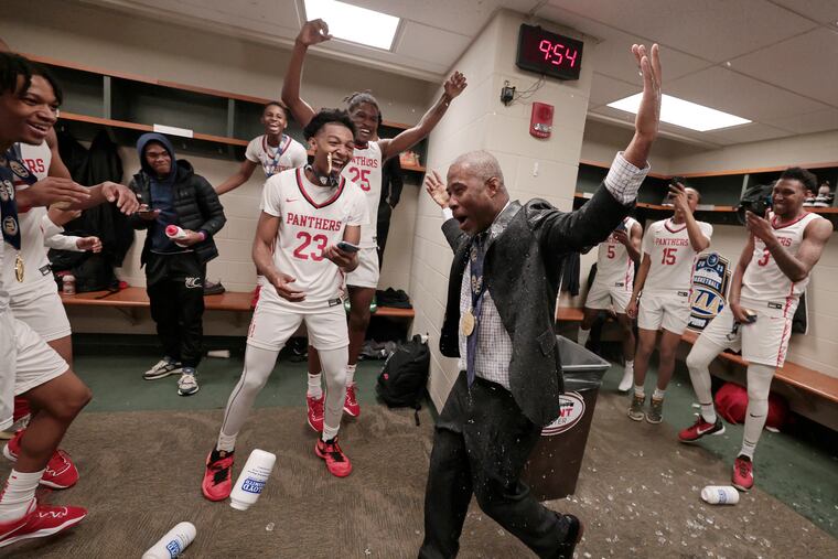 Imhotep players douse coach Andre Noble in celebration of their win over Exeter in the PIAA 5A boys' basketball final at the Giant Center in Hershey.
