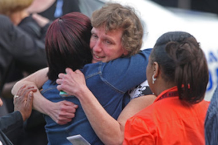 Flora Liczbinksi, the officer's sister, offers hugs to friends waitingto get into the funeral home to offer their support.