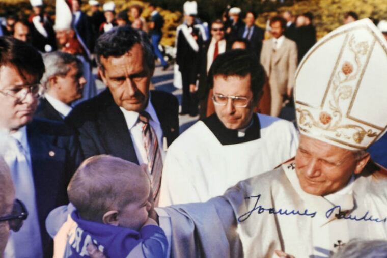 In a photo taken by Eagles team photographer Ed Mahan, Jim Murray's newborn son John Paul is blessed by Pope John Paul II following a Mass on Logan Circle in 1979. Jim was general manager of the Eagles at the time.