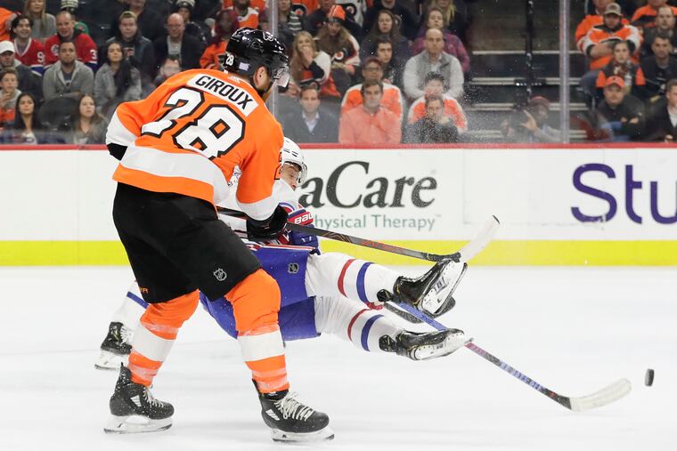 Montreal Canadiens center Max Domi falls down as the Flyers' Claude Giroux moves in during the third period.
