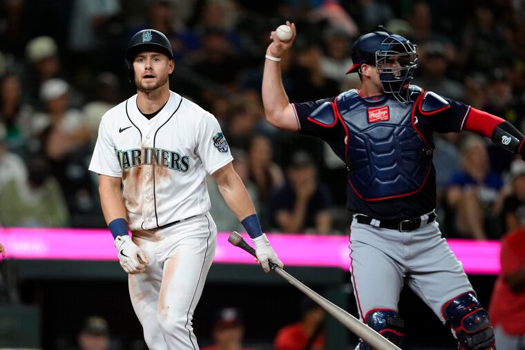 Seattle's Jarred Kelenic walks away after striking out while Washington Nationals catcher Riley Adams throws the ball back during the 11th inning Tuesday.