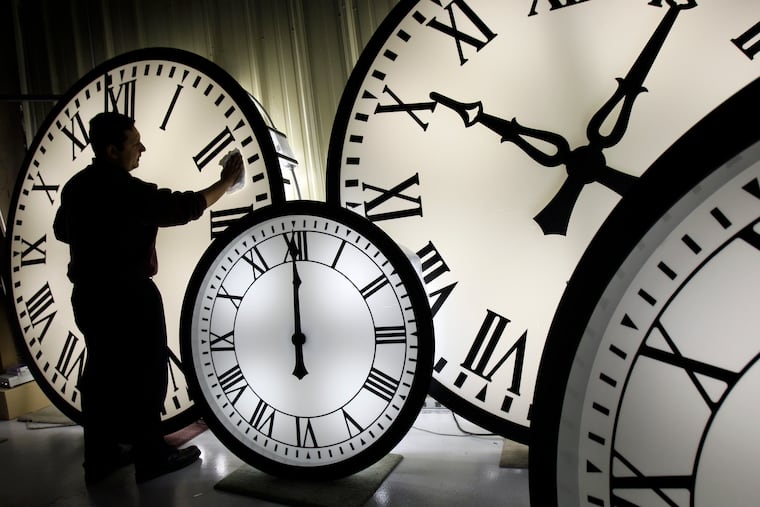 A clock-factory employee in New England clearns the face of an 84-inch Wegman. The clocks will be moving ahead an hour early Sunday to the delight, and dread, of the masses.