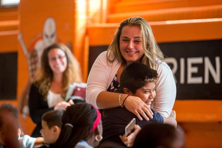 Jayda Pugliese, a fifth-grade math and science teacher, gets a big hug from student David Perez at Jackson Elementary in South Philadelphia.