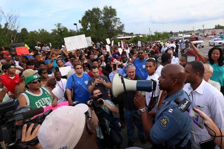 Missouri State Highway Patrol Capt. Ronald Johnson addresses the crowd of protesters, asking them to stay on the sidewalk and not block traffic Thursday, Aug. 14, 2014, in Ferguson, Mo. The Missouri Highway Patrol seized control of a St. Louis suburb Thursday, stripping local police of their law-enforcement authority after four days of clashes between officers in riot gear and furious crowds protesting the death of an unarmed black teen shot by an officer. (AP Photo/St. Louis Post-Dispatch, David Carson)