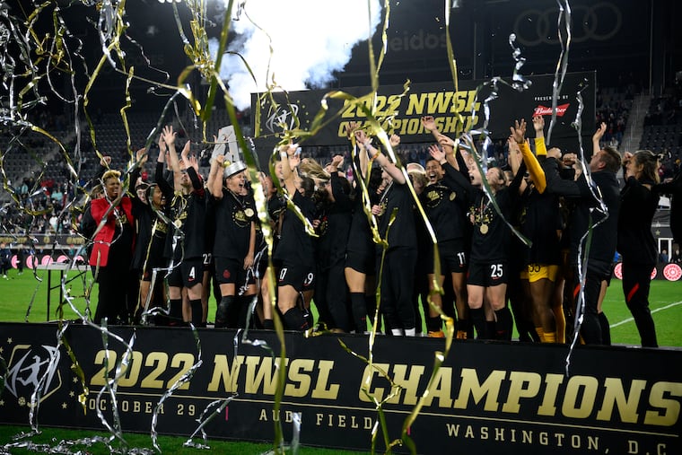 Portland Thorns players celebrate with the trophy after winning the NWSL championship game.