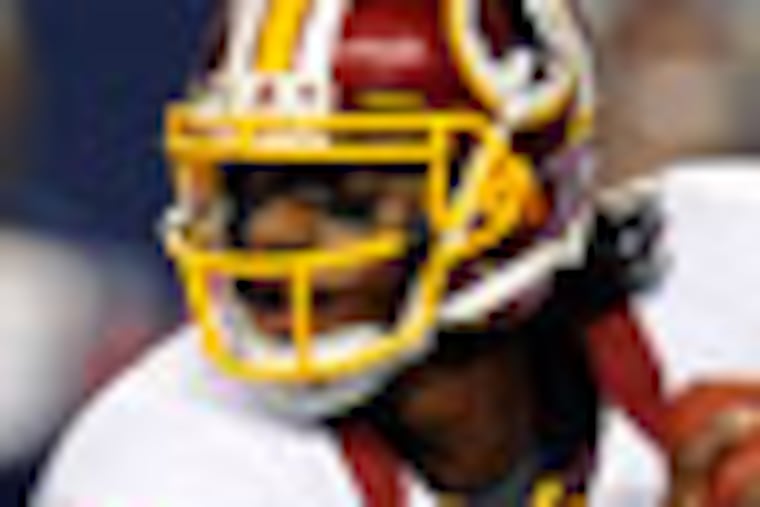 Washington Redskins quarterback Robert Griffin III (10) scrambles out of the pocket in the second half of an NFL football game against the Dallas Cowboys, Thursday, Nov. 22, 2012, in Arlington, Texas. (AP Photo/Matt Strasen)