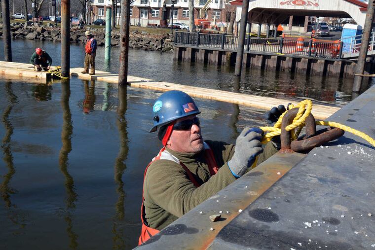 John Cortez, right, and Simpson & Brown Marine & Land Construction skilled laborers secure floating stages as they work on the Fixed Access Pier and Floating Day Docks project that is under construction at the Bristol Wharf on Monday February 6,2017.
