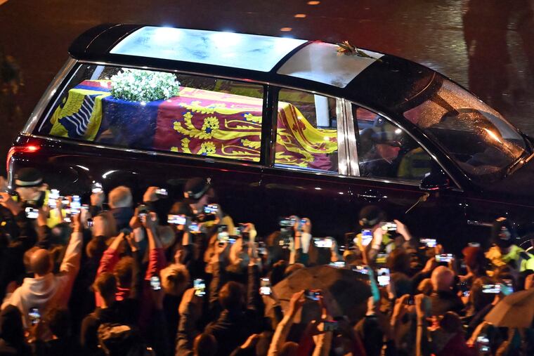 The coffin of Queen Elizabeth II in the royal hearse travels to Buckingham Palace in London on Tuesday.
