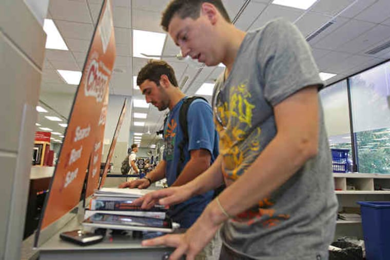 At the Villanova University bookstore, seniors Gregory Dyer (left) and Paul Passariello use iPads to rent books from Chegg.com, which is working with the store to offer 620 titles for rental this year.