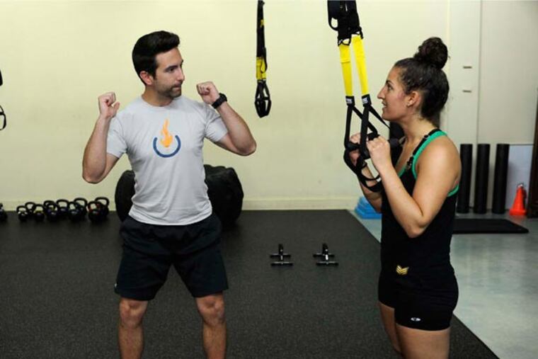 Ben Supik, left, co-owner of Activate Body Potential, a boutique gym in the Clipper Mill business area, works on technique with client Jordan Trinagel, July 18, 2014, in Baltimore. (Barbara Haddock Taylor/Baltimore Sun/MCT)