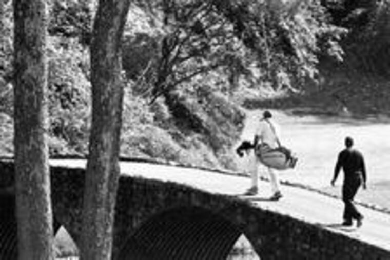 Tiger Woods and his caddie, Steve Williams, cross the Hogan Bridge to the 12th green at Amen Corner, the celebrated 12th and 13th holes at Augusta National.