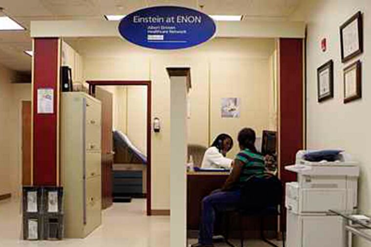 Nurse Practitioner Angela Stewart, behind desk, talks with Danecia Berrian, who needs a physical for a job, while at the Einstein at ENON walk-in clinic at the Enon Tabernacle Baptist Church, ( Bonnie Weller / Staff )