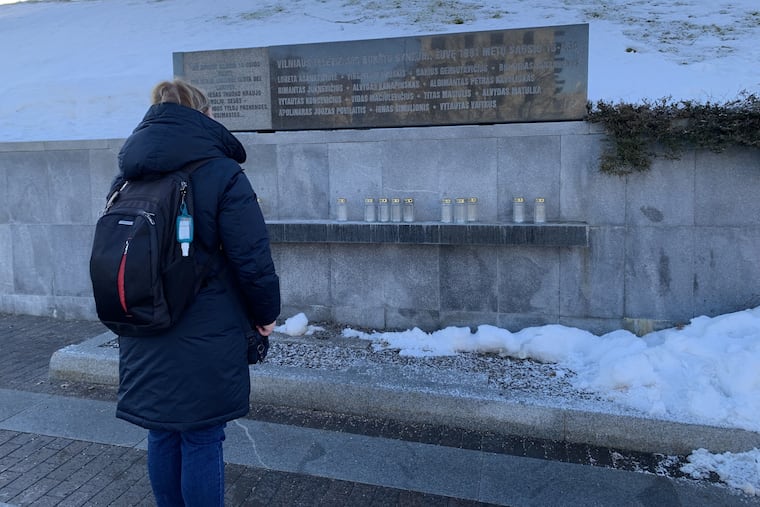 A Lithuanian woman reads the memorial stone to 14 citizens who were killed by Soviet bullets and tanks on Jan. 13, 1991, while defending the TV tower in the capital, Vilnius, against Moscow's efforts to overturn Lithuania's declaration of independence from the Soviet Union.