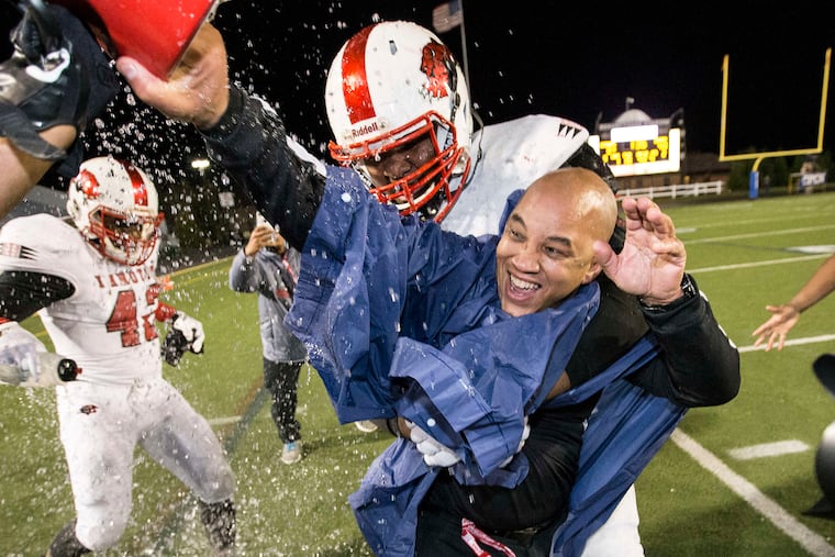 Imhotep head coach Albie Crosby gets the requisite victory shower in the final minutes of the Panthers' 40-3 victory over Erie Cathedral Prep in the Class 3A state championship game Dec. 19. Crosby was named state 3A coach of the year by Pa. football writers.
