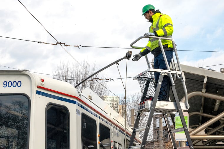 Light rail vehicle worker Aaron Daniels installs a slider on trolley at the 40th Street trolley portal Wednesday, Dec. 17, 2025, before a SEPTA tour/ride into the tunnel to update the news media on overhead wire repairs in the closed tunnel due to unexpected issues from new slider parts.
