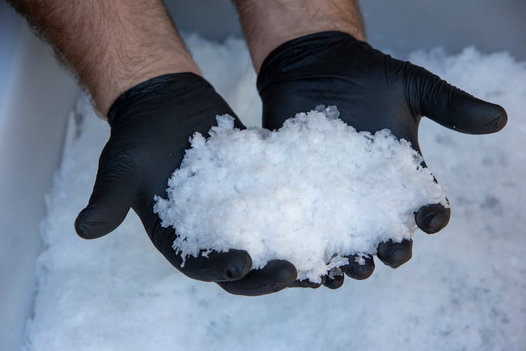Dave Burris, owner of Henlopen Hand Crafted Sea Salt, with two handfuls of sea salt flakes he manufactures in Lewes, Delaware. This salt is ready for packaging. Photograph taken on Wednesday, June 23, 2021. Dave makes sea salt flakes from sea water from Atlantic Ocean at Lewes, DE.