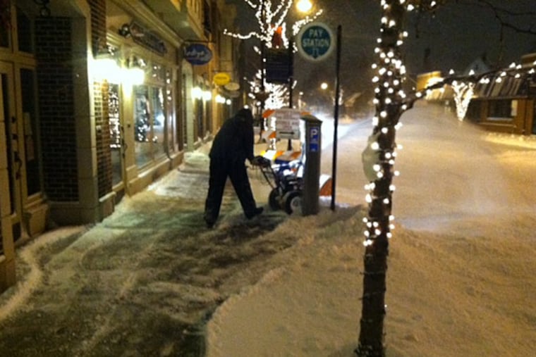 Workers clear snow from a sidewalk in Collingswood early Friday morning. (Lissa Atkins/Philly.com)