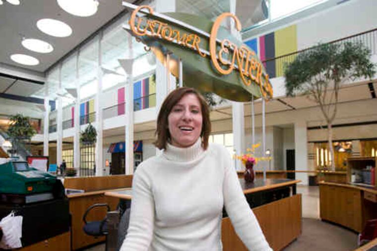 Melonie Messins, marketing director at Plymouth Meeting Mall, stands behind the counter where an employee sold a Powerball ticket to someone whose life is going to change dramatically.