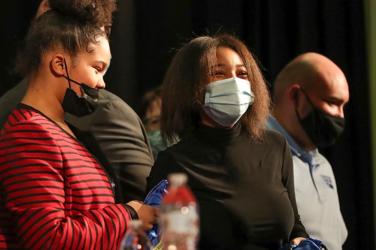 Student Malinda Saunders (center) smiles after filling out an application form for a college-access program at Frankford High School. She and fellow Frankford student Mirranda Cunningham (left, red shirt) are among the nearly 2,000 students who will benefit from a $5 million college-access grant awarded to the Philadelphia Education Fund.