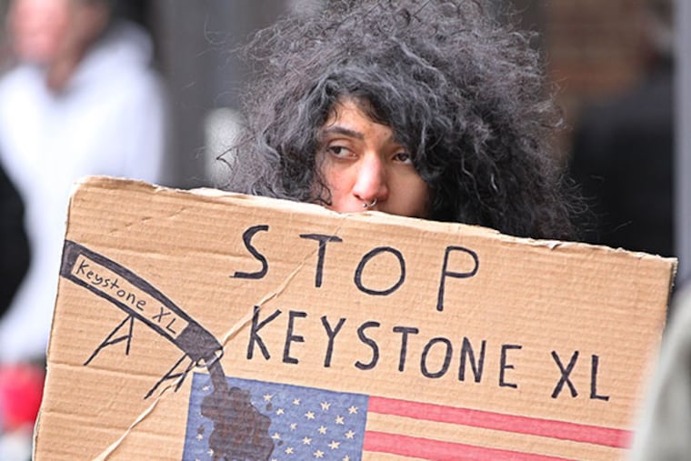 One of the protestors stood in the eastern courtyard of the Federal building protesting the the Keystone XL Pipeline on Monday, March 10, 2014. ( MICHAEL BRYANT / Staff Photographer )