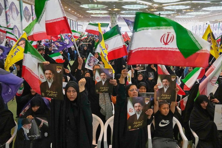 Government supporters hold Iranian flags and pictures of Iran's Supreme Leader, Ayatollah Mojtaba Khamenei, during a ceremony honoring the armed forces and those killed in the war with Israel and the U.S. at the Imam Khomeini Grand Mosque in Tehran, Iran, Sunday, May 24, 2026.